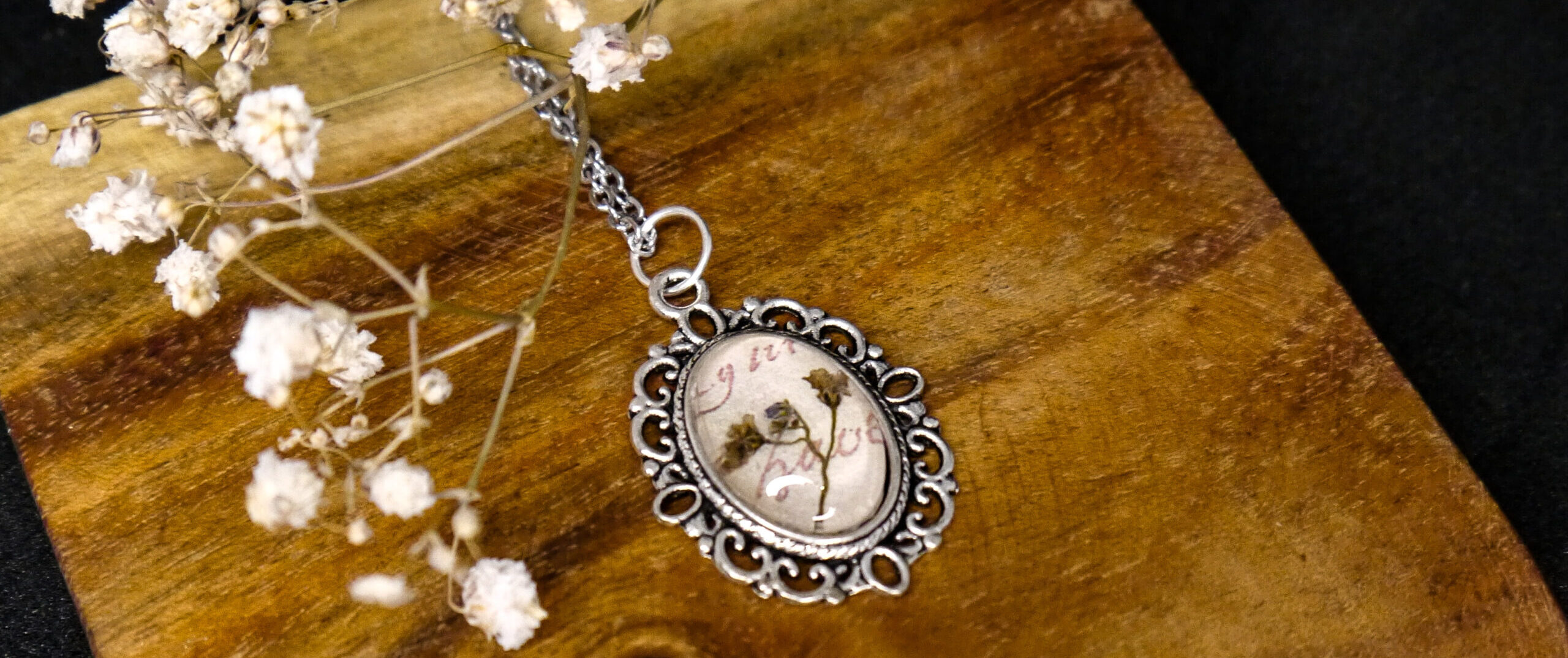 Cabochon-Medaillon mit antikem Briefpapier und einer Vergissmeinnichtblüte.