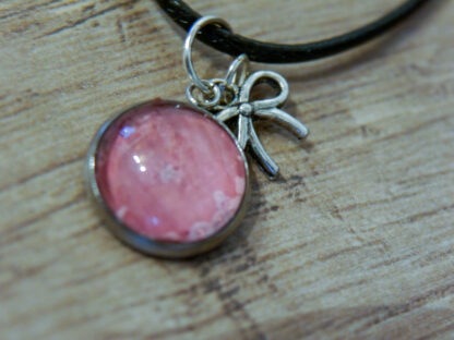 Detailaufnahme Cabochon-Anhänger mit rosa Rosenblüte und einem Schleifen-Charm