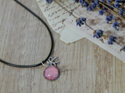 Cabochon-Anhänger mit rosa Rosenblüte und einem Schliefen-Charm