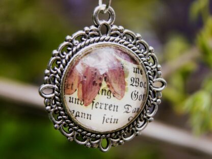 Cabochon-Anhänger mit echter Blüte & antikem Schriftfragment im Vintagestil