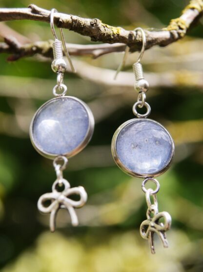 Ohrringe mit Edelstahlhaken, 12 mm Glascabochons mit eingefasster blau-grauer Hortensienblüte und dekorativem Schleifencharm – handgefertigter Naturschmuck.